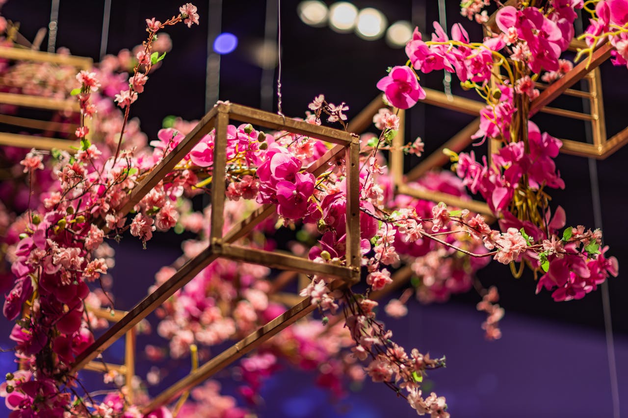 A close-up of a pink floral arrangement hanging elegantly against a blurred background.